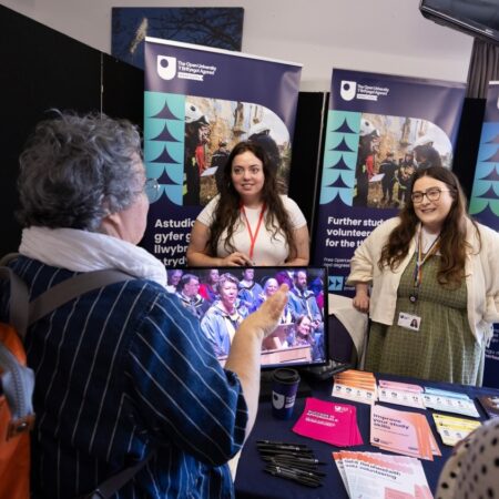 Booth with two exhibitors and display boards featuring service information.