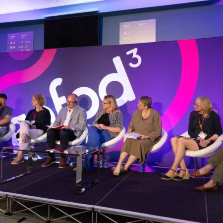 Panel of six speakers seated on stage during a conference, “gofod3” branding visible.